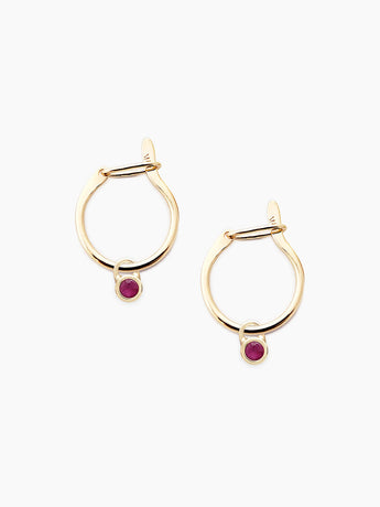 Gold hoop earrings with ruby gemstones on a white background