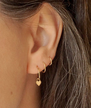 14k solid gold huggie hoops with a dangling heart charm