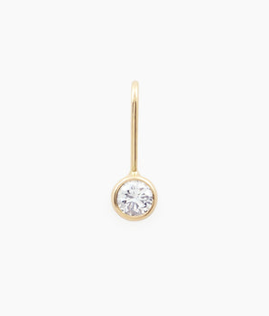 Minimalism bezel-set diamond charm by Irina Victoria Jewelry  on an off-white background.