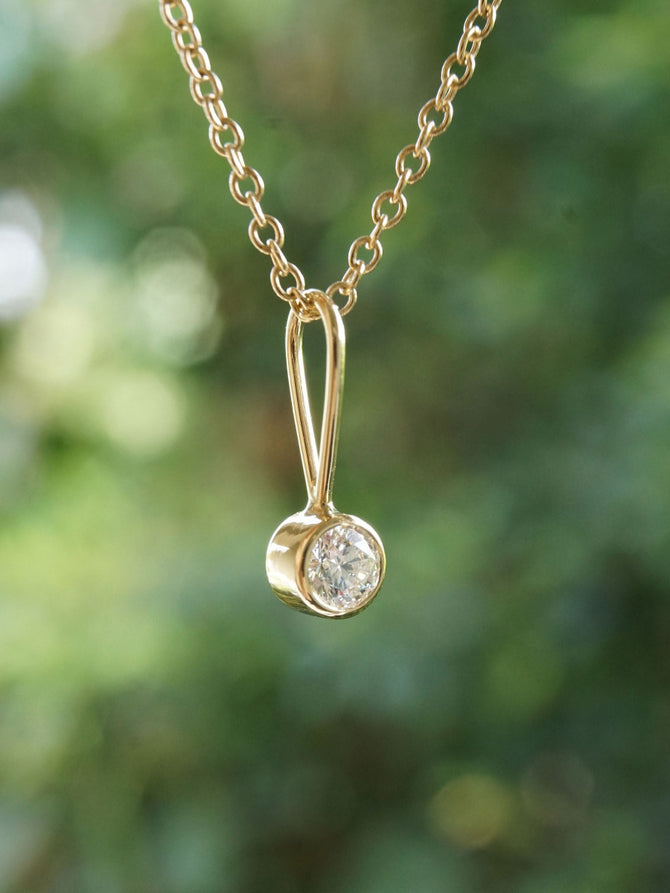 Close up of the classic solid gold diamond charm by Irina Victoria Jewelry