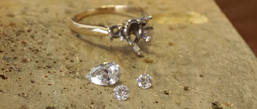 Disassembled diamond engagement ring on a jewelers bench
