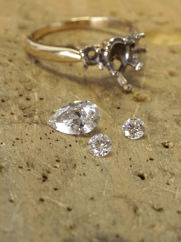 Disassembled diamond engagement ring on a jewelers bench