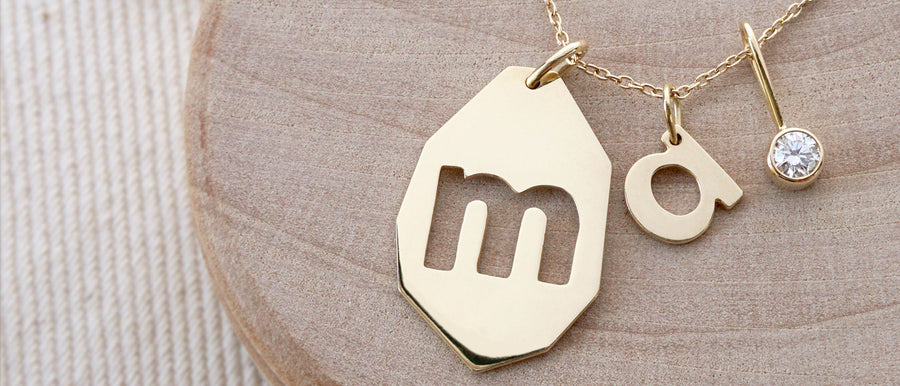 Solid gold necklace with a diamond, 'm' and 'a' letter charms by Irina Victoria Jewelry