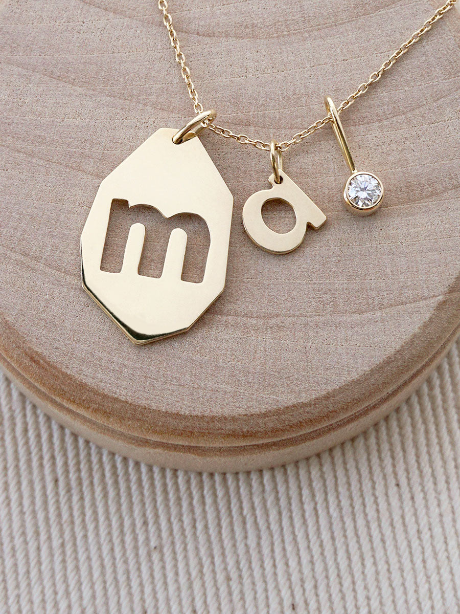 Gold necklace with a diamond, 'm' and 'a' letter charms by Irina Victoria Jewelry